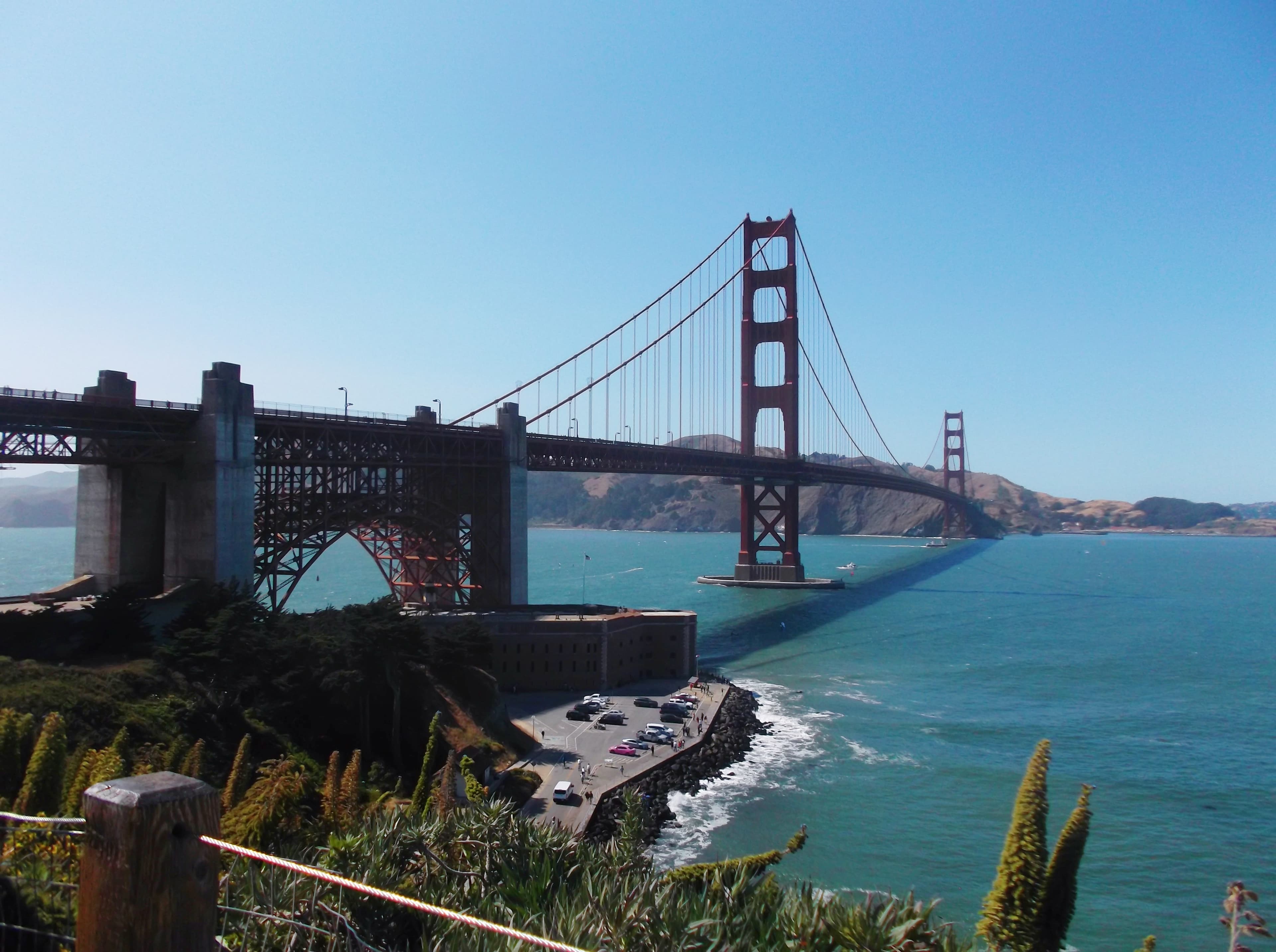 The Golden Gate Bridge spanning the bay under a clear blue sky.