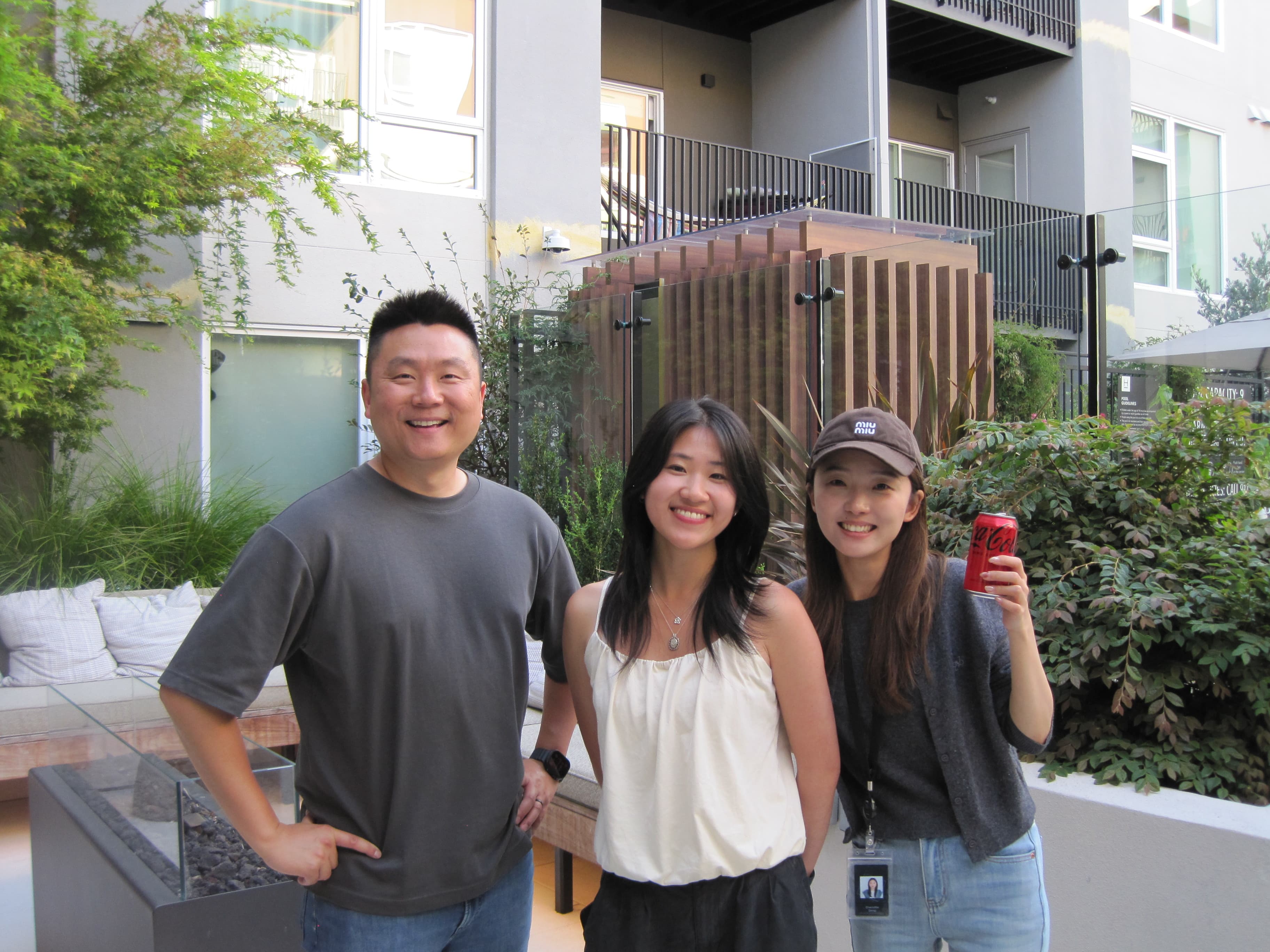 Jodie standing with two mentors outdoors at an apartment courtyard.